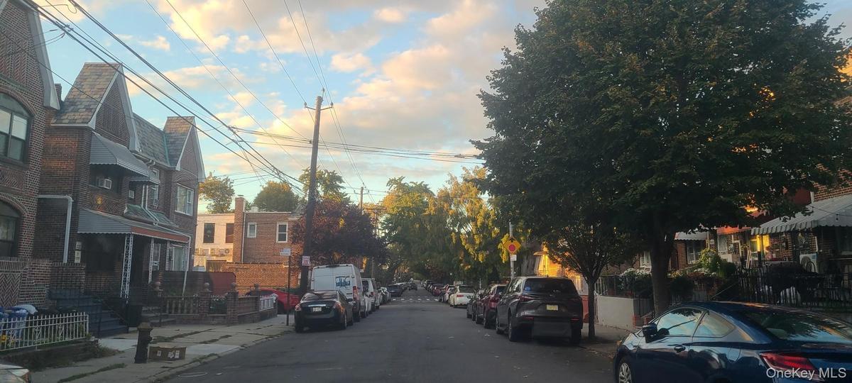 View of asphalt road featuring sidewalks, traffic signs, and curbs
