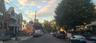 View of asphalt road featuring sidewalks, traffic signs, and curbs