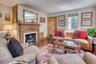 Living room featuring wood-type flooring and a fireplace with flush hearth