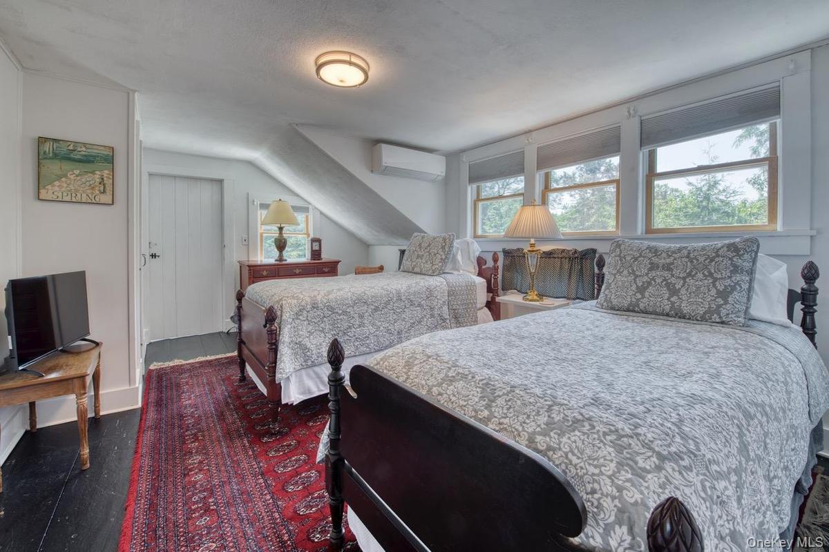 Bedroom featuring dark wood-type flooring and a wall mounted air conditioner