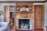 Detailed view of wood finished floors, beam ceiling, and a fireplace