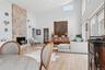 Living area with high vaulted ceiling, wood finished floors, and a stone fireplace