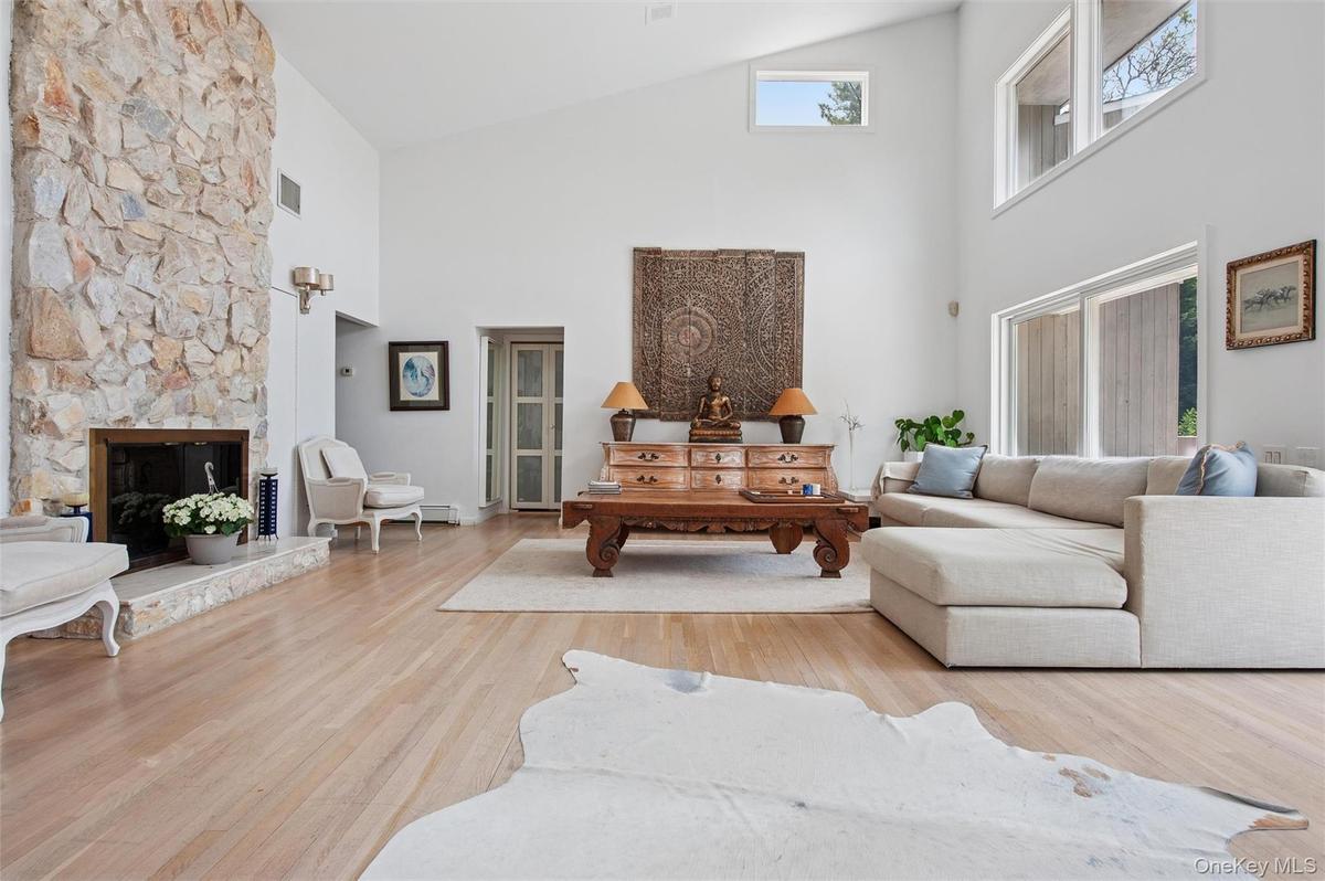Living area featuring high vaulted ceiling, wood finished floors, and a fireplace