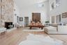 Living area featuring high vaulted ceiling, wood finished floors, and a fireplace