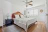 Bedroom featuring wood finished floors, a baseboard radiator, baseboards, and ceiling fan