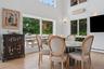 Dining room with a wall unit AC, wood finished floors, a high ceiling, and a baseboard radiator