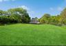 View of green lawn featuring a wooded view