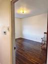 Unfurnished room featuring baseboards and dark wood-style flooring