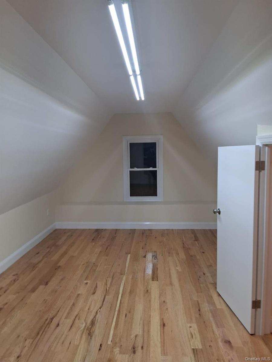Bonus room featuring light wood-style floors and vaulted ceiling