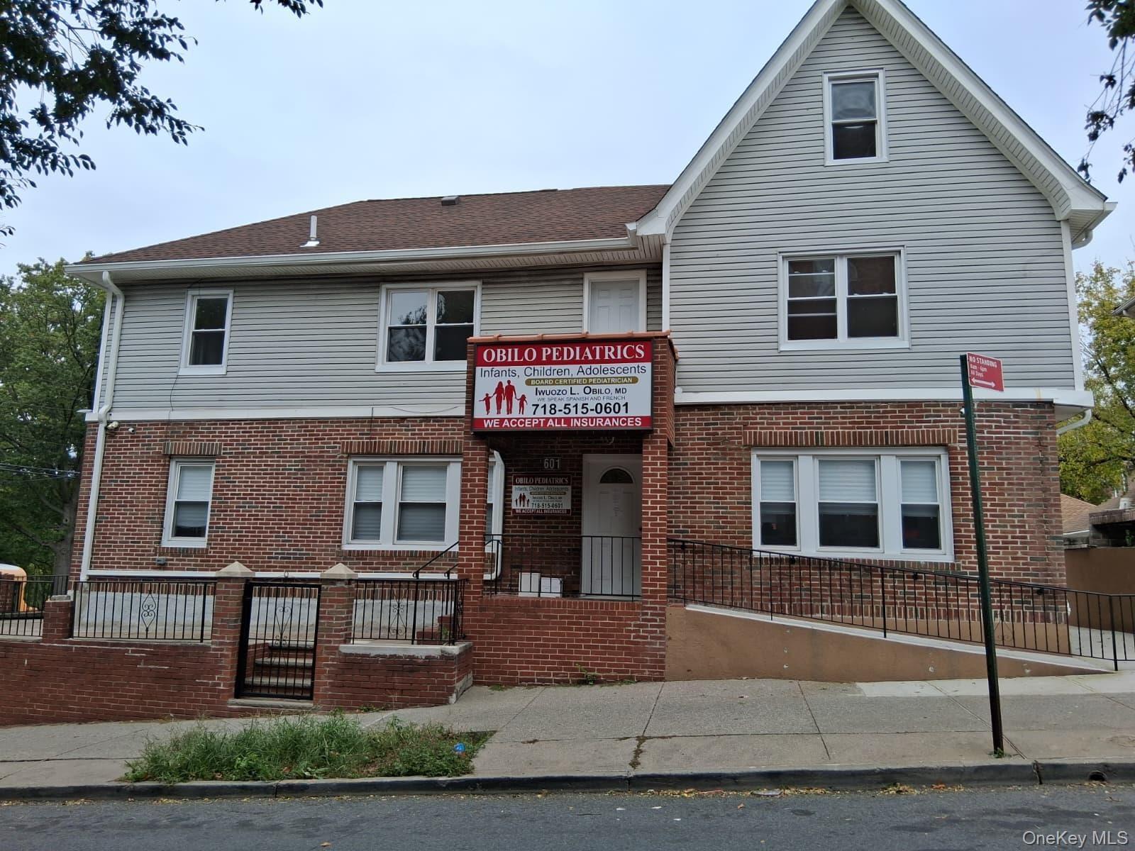 View of front facade featuring brick siding and a fenced front yard