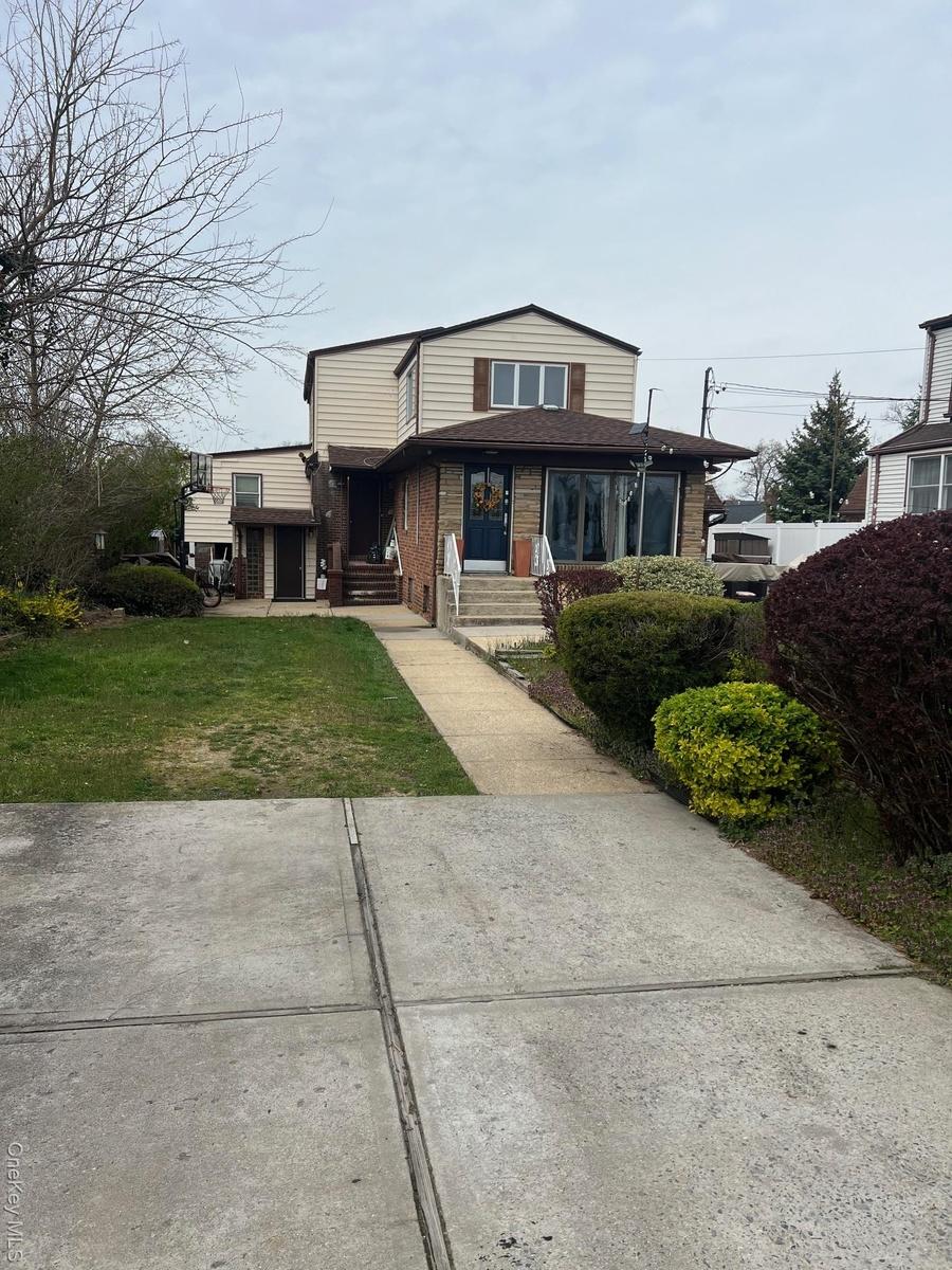 View of front facade with brick siding and a front yard