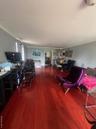Living room with dark wood-type flooring and crown molding
