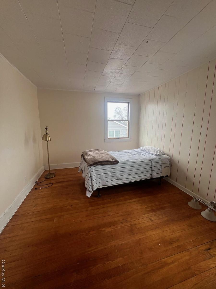 Bedroom with baseboards and hardwood / wood-style flooring