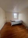 Bedroom with baseboards and hardwood / wood-style flooring