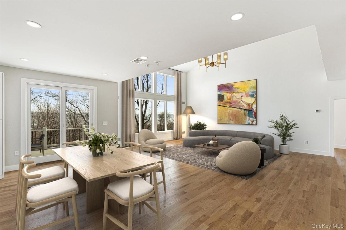 Breakfast Room open to the Chef's Kitchen and Great Room with deck access virtually staged