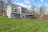 Back of property featuring a yard and a wooden deck