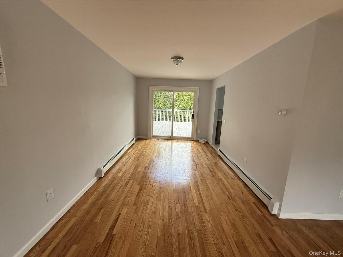 Spare room featuring a baseboard radiator and light wood-style floors