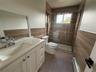 Full bathroom featuring tile walls, vanity, a baseboard heating unit, a shower stall, and dark tile patterned floors