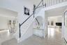 Stairway with a baseboard heating unit, tile patterned flooring, and a towering ceiling