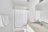 Bathroom with light tile patterned floors, vanity, and shower / bath combination with curtain