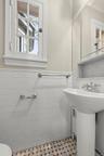 Half bath featuring tile walls and a wainscoted wall