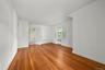 Empty room featuring wood finished floors and radiator heating unit