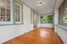 Unfurnished sunroom featuring a textured wall and wood finished floors