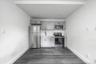 Kitchen with gray cabinets, stainless steel appliances, light countertops, and dark wood-style floors