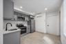 Kitchen with gray cabinets, stainless steel appliances, light countertops, recessed lighting, and a wall mounted air conditioner