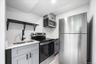 Kitchen featuring open shelves, stainless steel appliances, light countertops, and gray cabinets