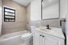 Full bath featuring tile walls, vanity, and shower / bath combination