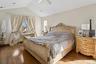 Bedroom with vaulted ceiling, wood finished floors, and ceiling fan
