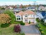 View of front of house with a residential view, decorative driveway, and stucco siding
