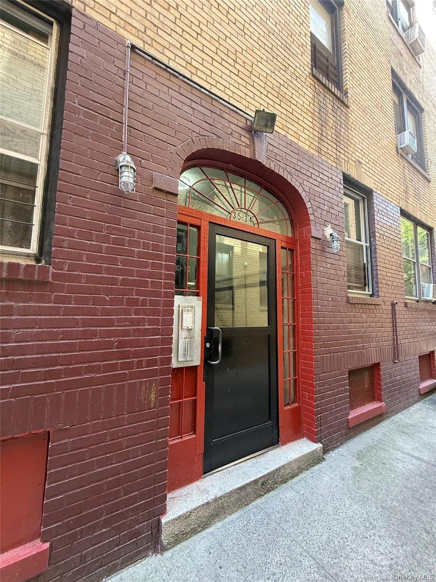 View of exterior entry featuring brick siding and cooling unit