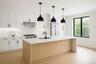 Kitchen featuring tasteful backsplash, stainless steel refrigerator, decorative light fixtures, and light stone countertops