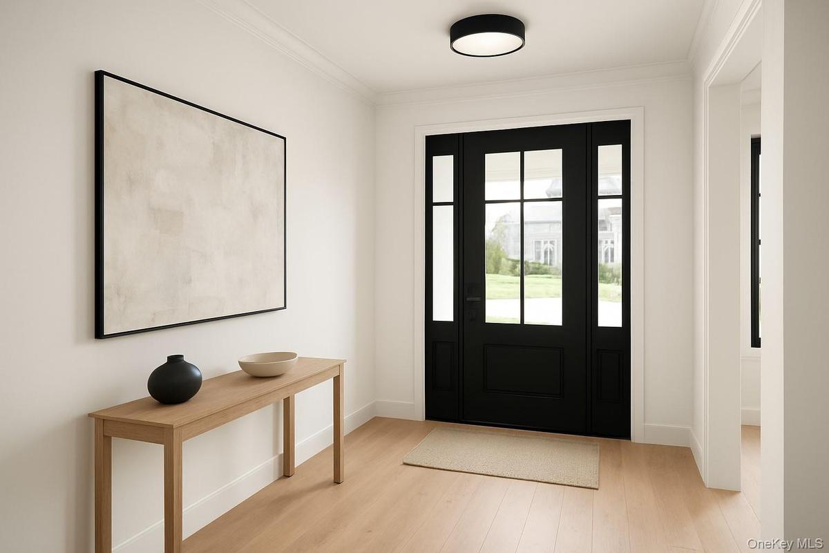 Entrance foyer with light wood-type flooring and crown molding