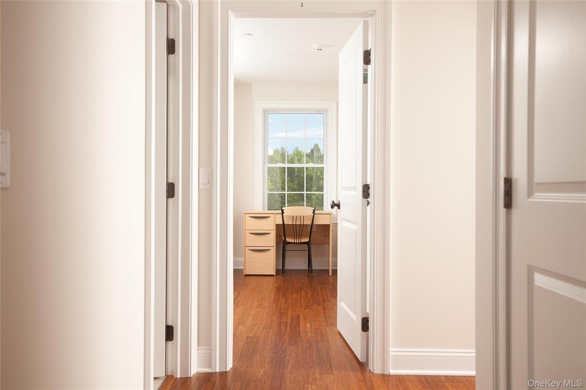Hall with dark wood finished floors and baseboards