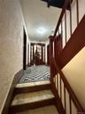 Staircase featuring a textured wall, a textured ceiling, and ornamental molding