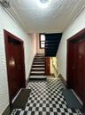 Staircase featuring a textured wall, a textured ceiling, and tile patterned floors