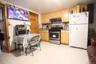 Kitchen with appliances with stainless steel finishes, light brown cabinets, under cabinet range hood, and light tile patterned floors