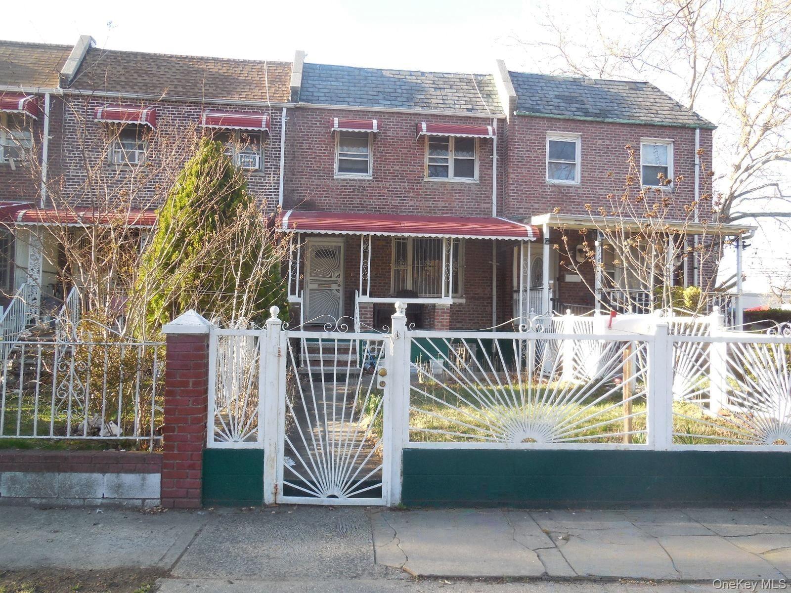 Traditional-style house with a gate, brick siding, and a fenced front yard
