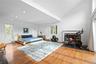 Bedroom with lofted ceiling, wood finished floors, and a brick fireplace