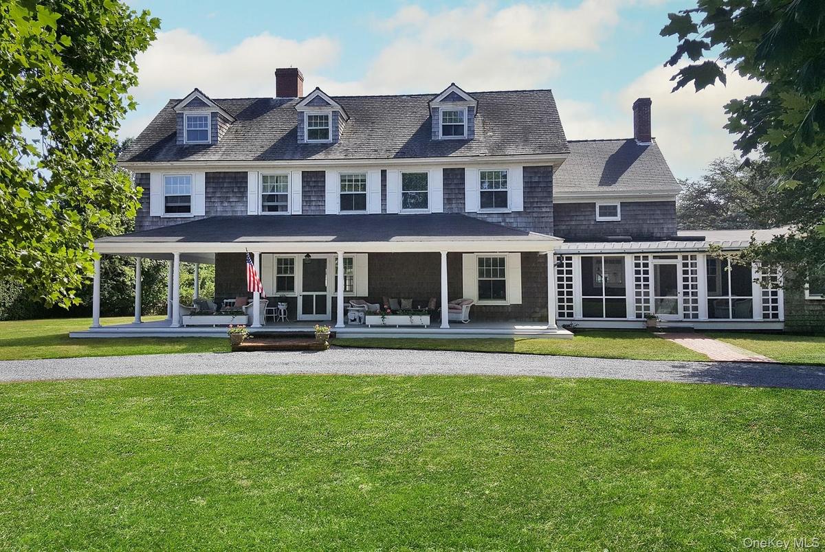 View of front facade with a covered porch, a sunroom/screened porch, and a front yard