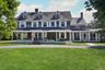 View of front facade with a covered porch, a sunroom/screened porch, and a front yard