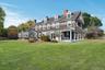 Rear view of property with expansive lawn, patio, and covered porch