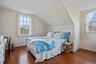 Guest Apt. Bedroom featuring dark hardwood flooring, multiple windows, and lofted ceiling
