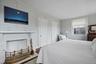 2nd Floor Primary Bedroom featuring hardwood flooring and a brick fireplace