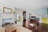 Sitting Room with Fireplace and Foyer with Stairs to Second Floor