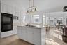 Kitchen with white cabinetry, ornamental molding, pendant lighting,