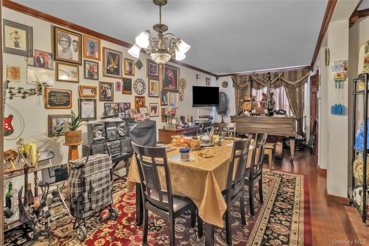 Dining area with crown molding, a chandelier, and dark wood-style flooring